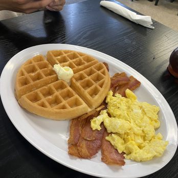 Breakfast plate with waffle, bacon, and eggs